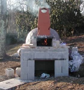 The oven is being handcrafted, stone by stone, with tremendous skill and  artistry