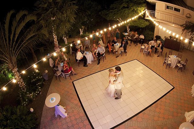scattered An evening garden setting with 2 round pools and an aisle  lined with rose petals,